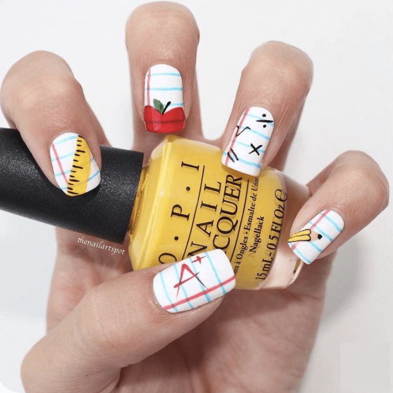 Short oval nails with red apple art and yellow pencil stripes for school teachers.