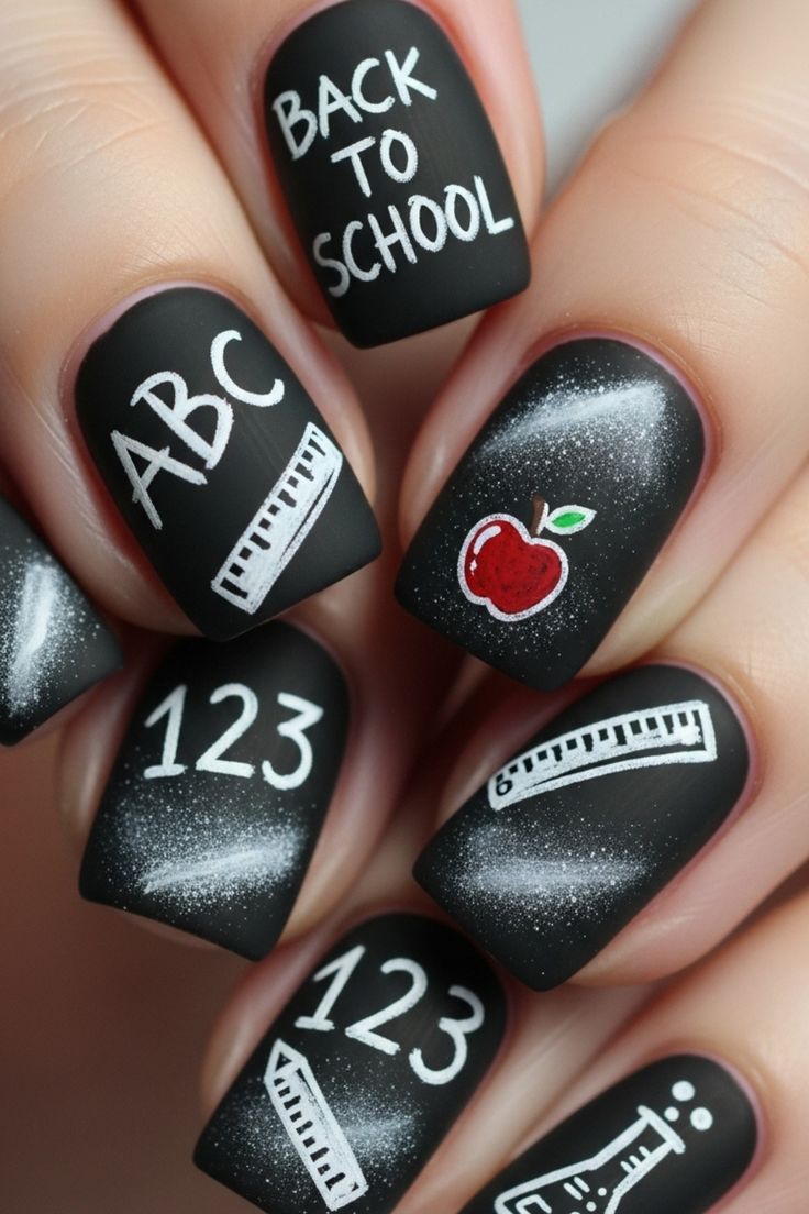 Medium almond black nails with matte finish and silver chrome school supply doodles.