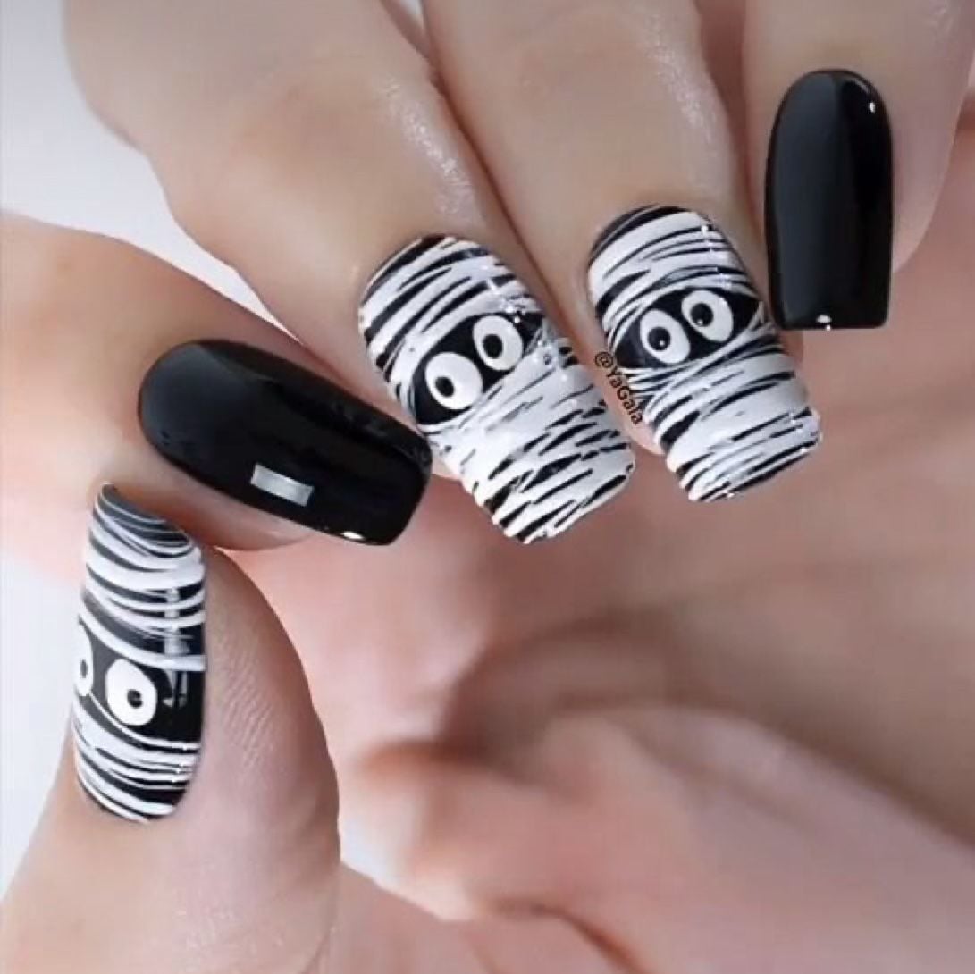 Square shaped black and white glossy mummy nail design for festive Halloween wear.
