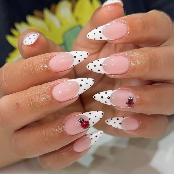 Timeless white french tip nails with black polka dots on almond glossy gel polish.