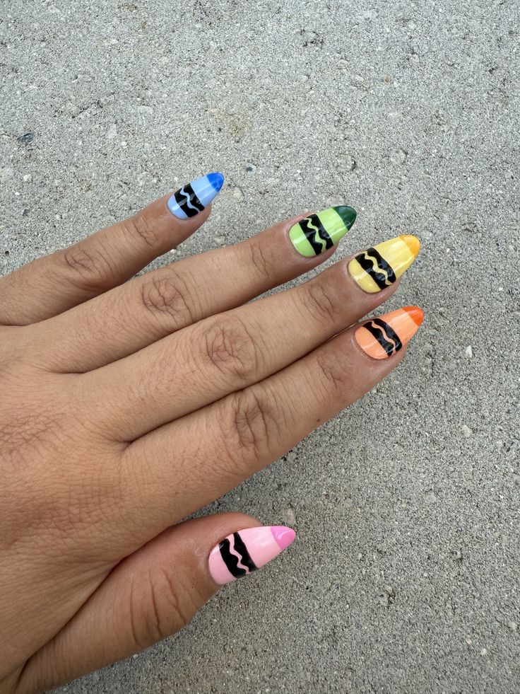 Square nails painted like classic yellow, green, and blue crayon tips with glossy polish.