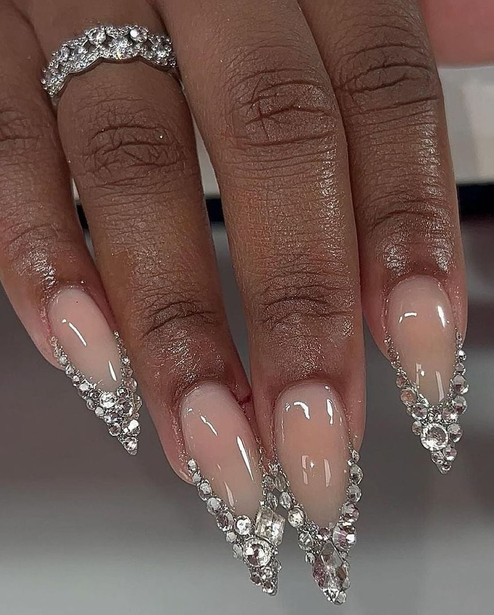 Medium almond sheer nude crystal rhinestone nails with natural gloss finish for bridal wear.