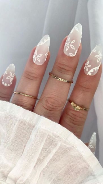 Almond shaped milky white nails with dried flower accents for a summer wedding.