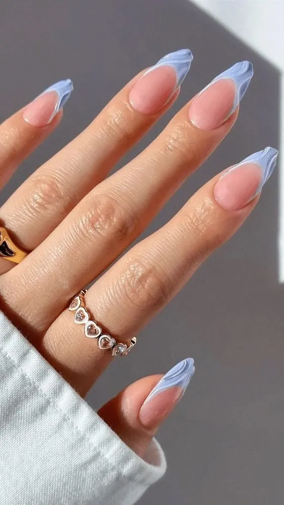 Varied color French tip nails with light blue pink and grey-blue tips creating modern rainbow effect