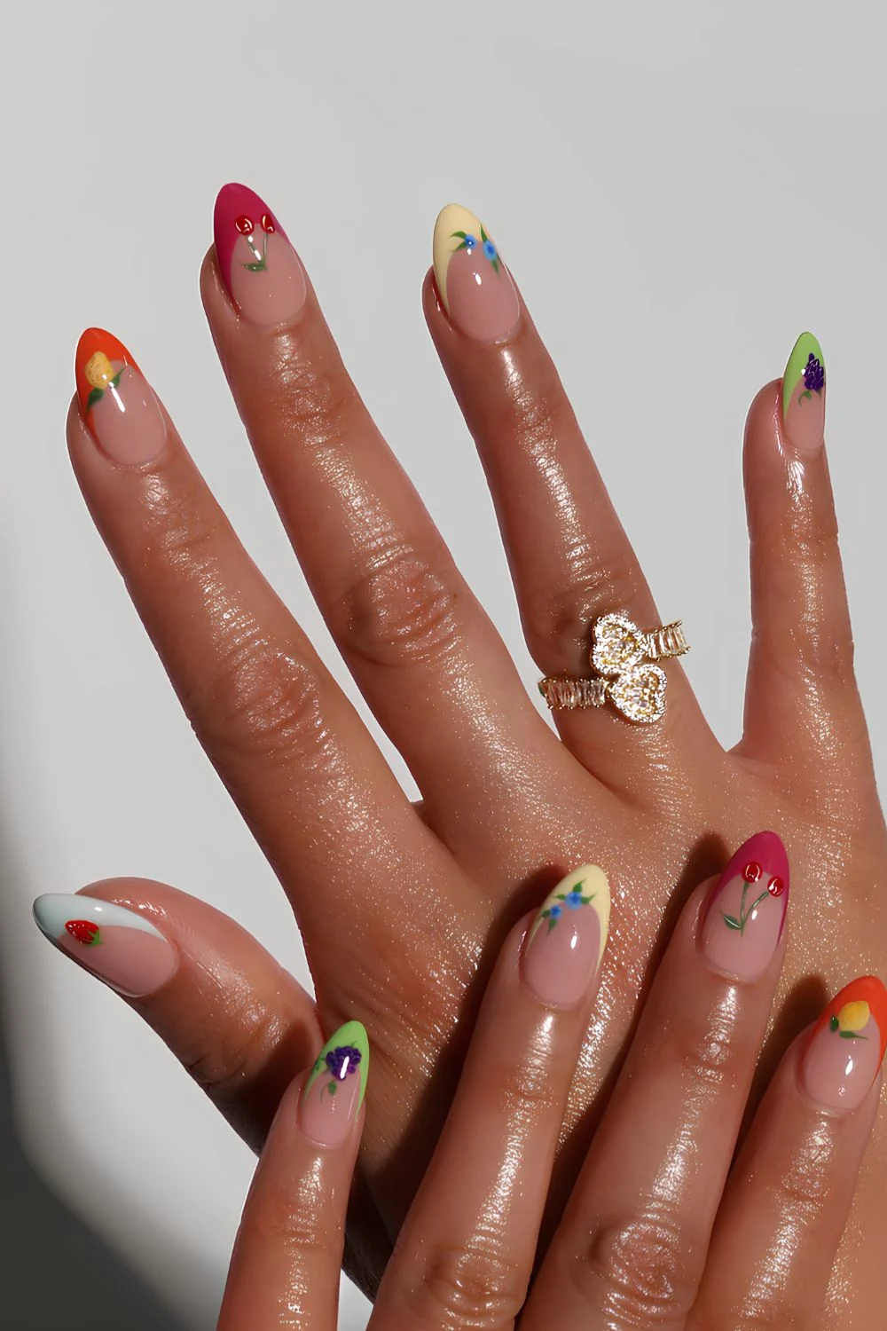 Modern French tip nails with inverted V-shaped white tips and black heart designs with glitter accents