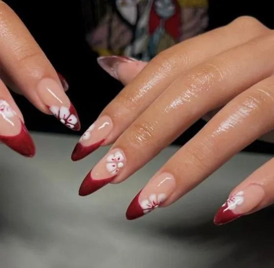 Sophisticated French tip nails with vibrant pink tips and gold accent lines with star embellishments