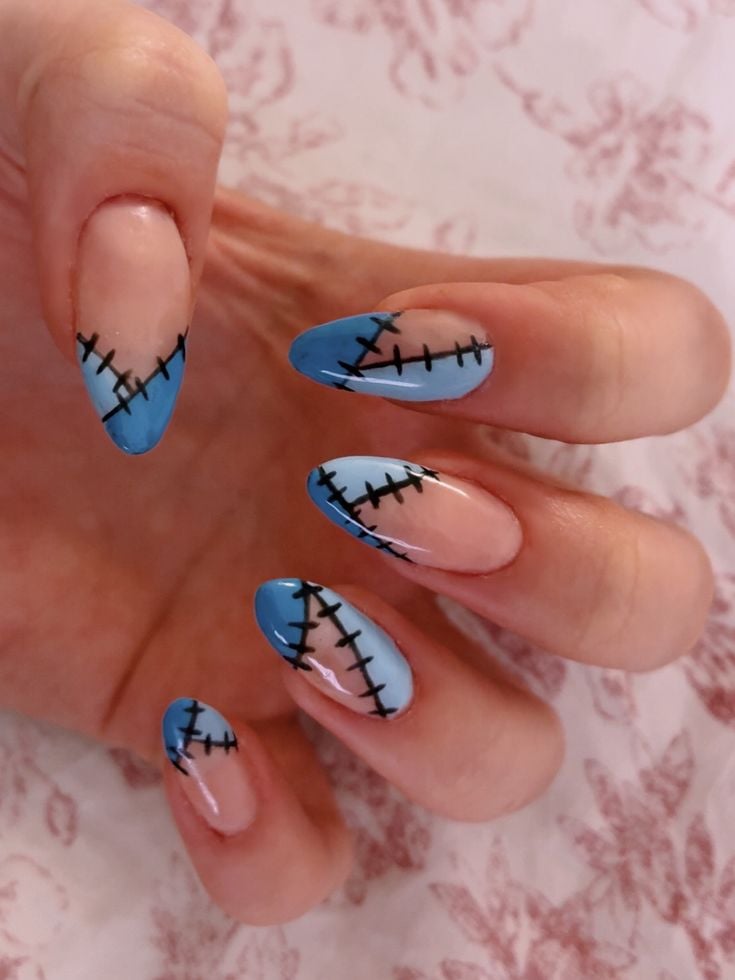 Coffin shaped matte blue and black nails with Frankenstein style stitching designs.