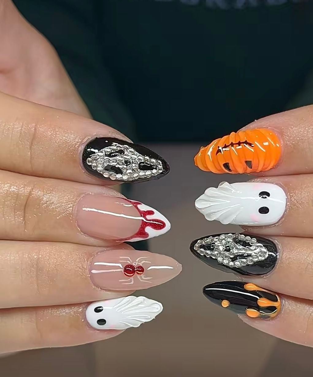 Coffin shaped orange, black, and white glossy nails with mixed Halloween art.