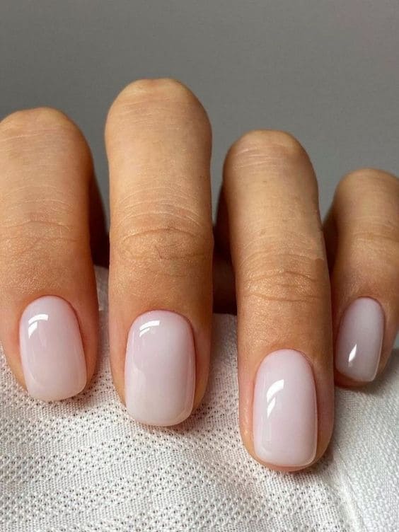 Oval shaped Korean style blush-tinted milky white nails for cute cafe outings.