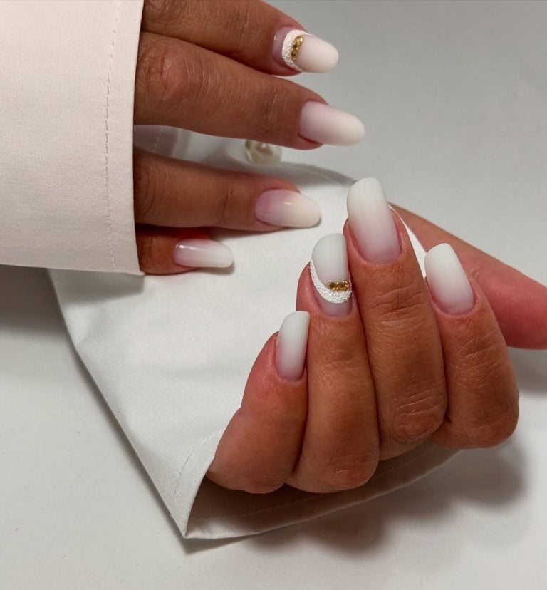 Almond shaped matte milky white nails with delicate white lace details for weddings.