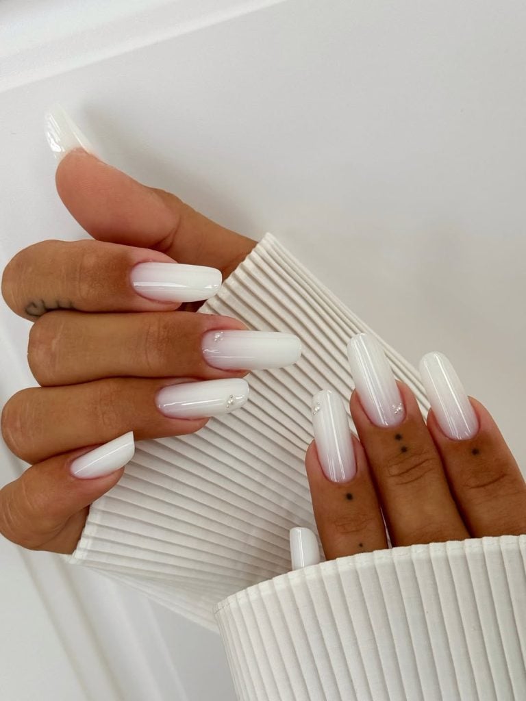 Long square shaped heavy cream milky white nails for a fashion show.