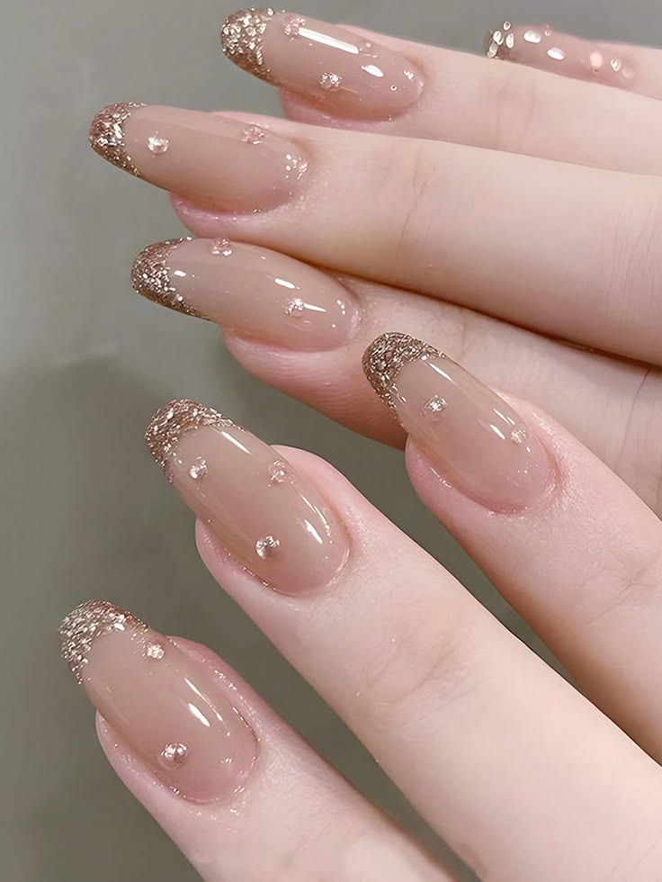 Nude Almond Shaped Nails With Rose Gold Glitter French Tips And Delicate Rhinestone Accents