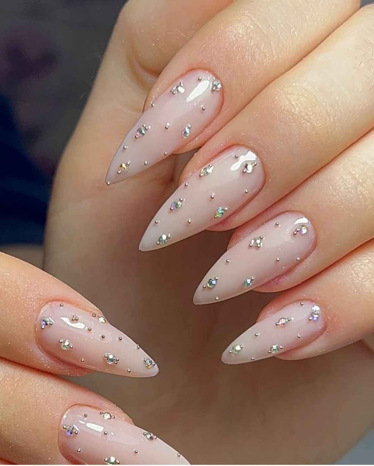 Medium almond nude pearl rhinestone nails with luminous gloss finish for engagement photos.