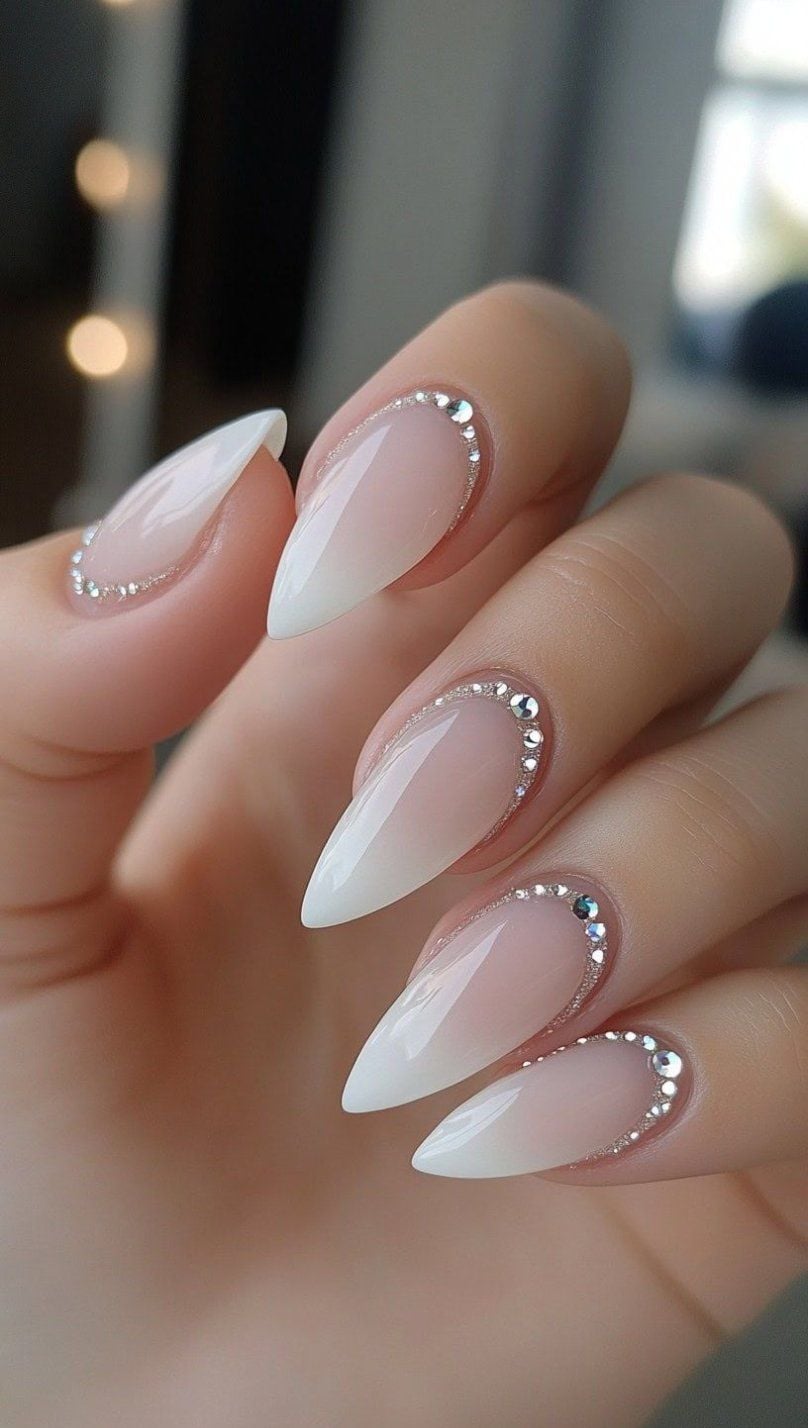 Long square nude french tip rhinestone nails with high shine finish for special occasions.