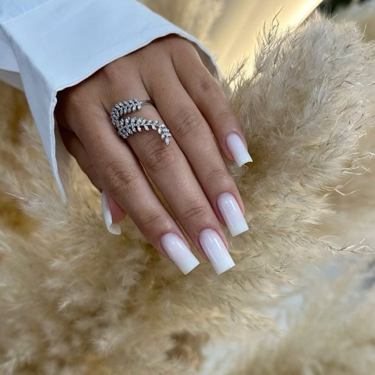 Medium square shaped milky white to nude ombre nails for an engagement photoshoot.