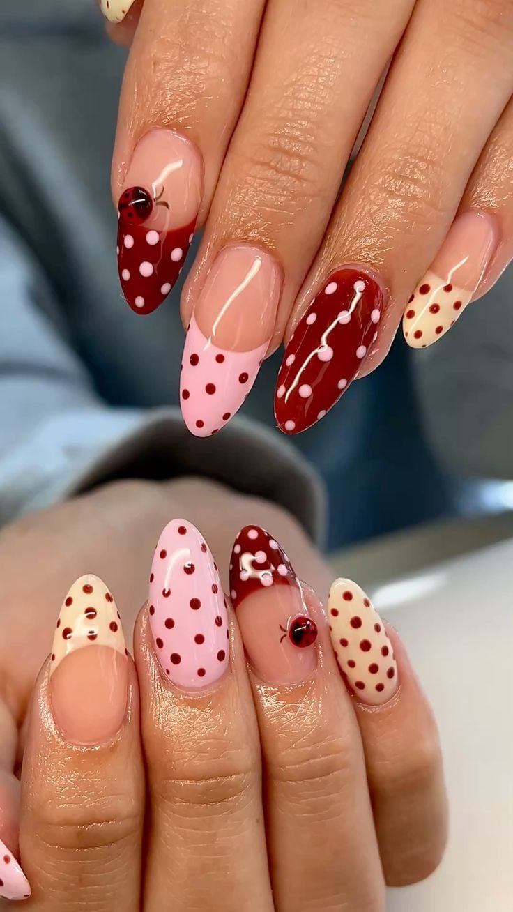 Bright red dot french tip nails on almond glossy base for holiday celebrations.