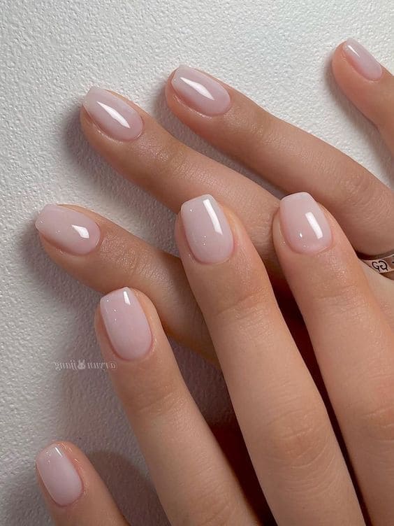 Oval shaped milky white nails with subtle silver shimmer for a winter party.