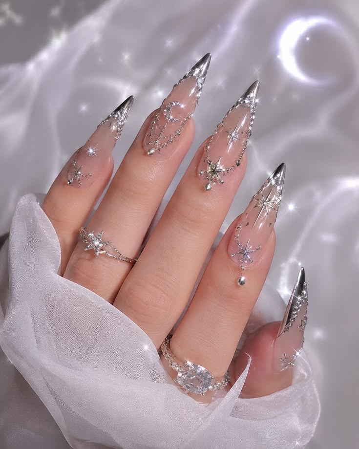 Long stiletto silver mirror chrome crystal glam nails with reflective finish for New Year's Eve.
