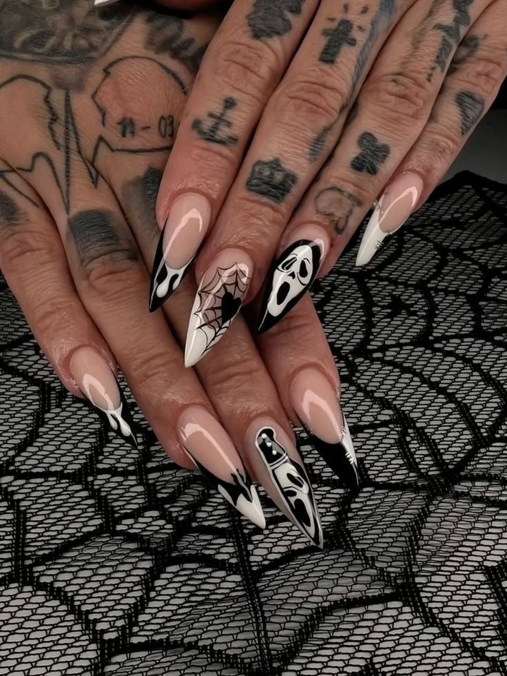 Squoval shaped glossy nude nails with tiny black spider and web details.